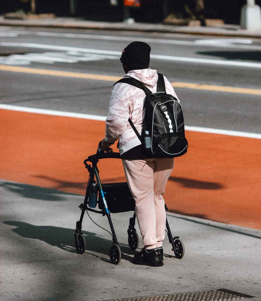 Person using walker on sidewalk