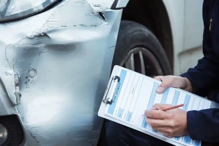 Someone doing work estimate on an accident car