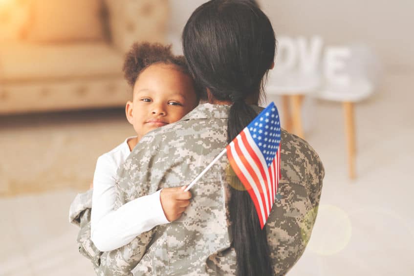 a soldier carrying her daughter