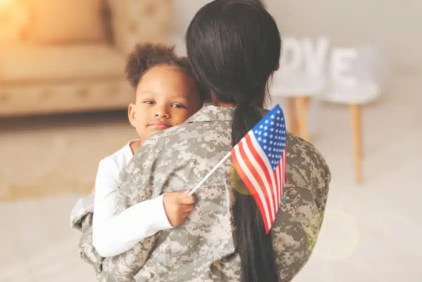 a soldier carrying her daughter