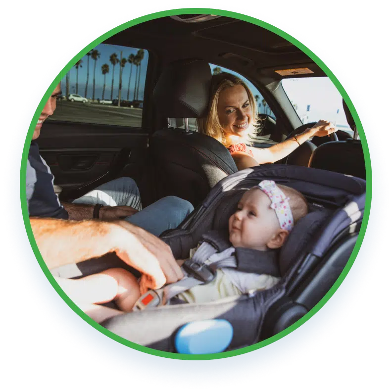A family in a car with a child strapped on a child's seat