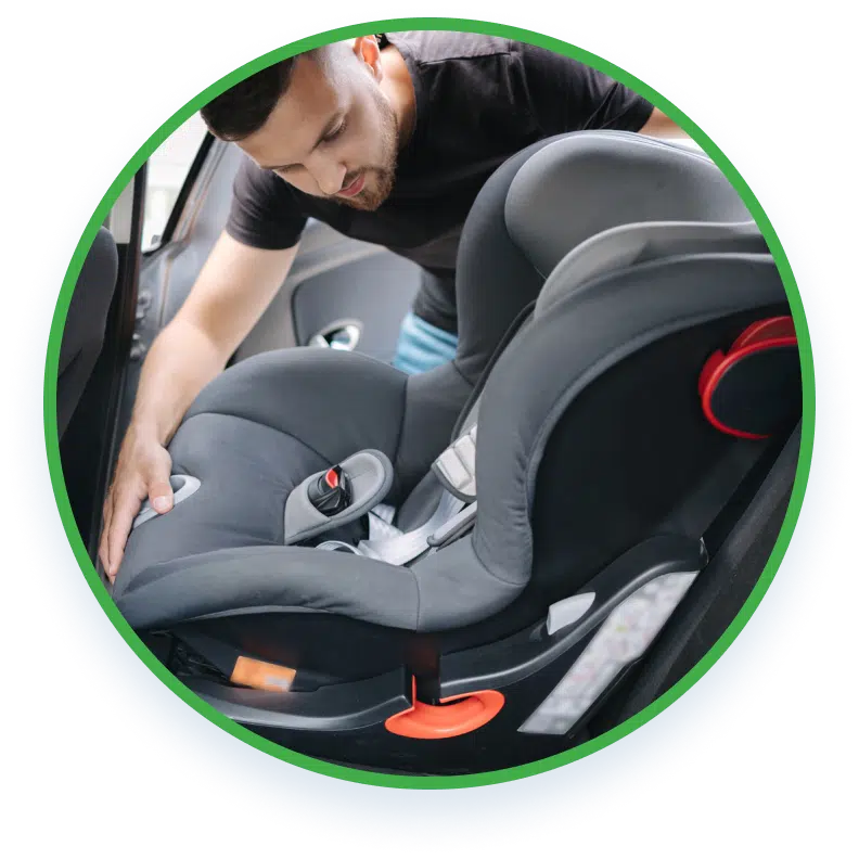 A man putting a child seat at the back of a car