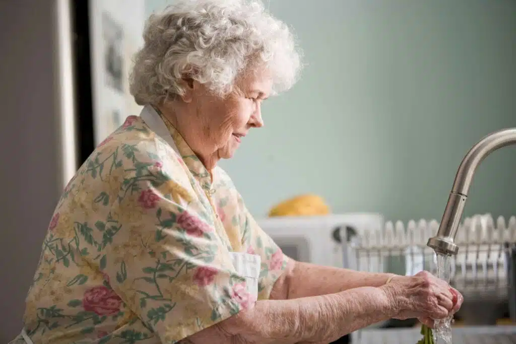 An elderly woman pouring water