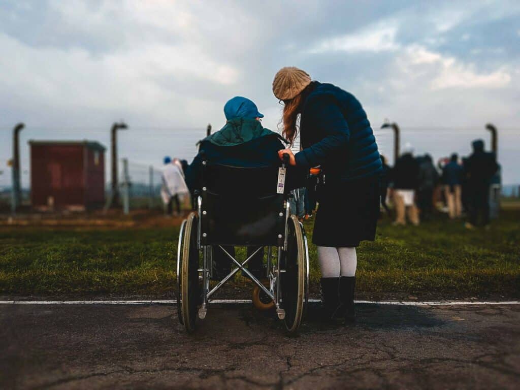 a lady helping another lady on the wheel chair