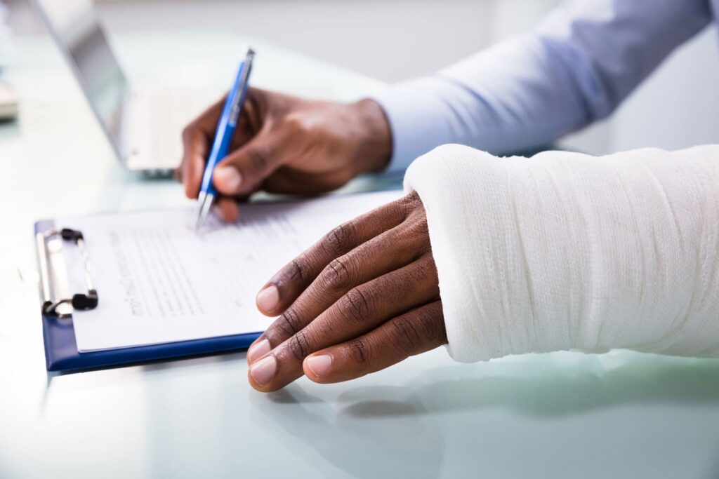 A man injured on his hand, and signing a document with the other hand