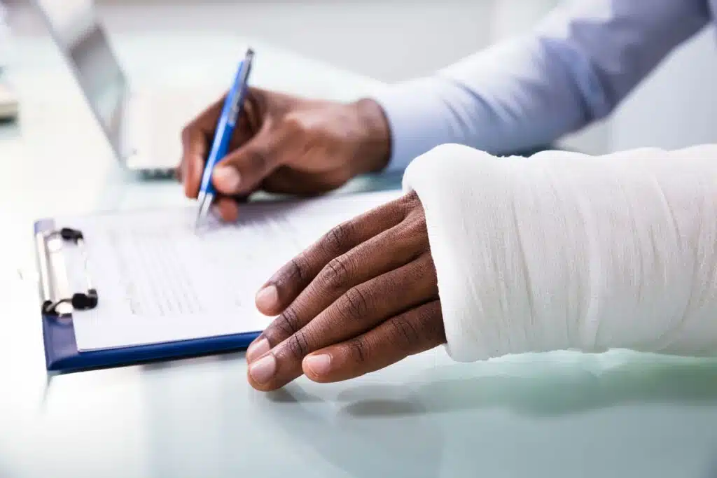A man injured on his hand, and signing a document with the other hand