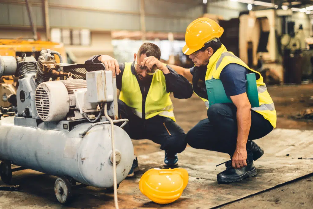 Fatigued construction worker kneeling at work site - construction accident attorney