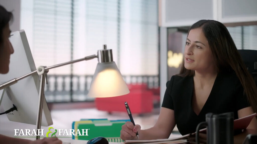 Attorney Dalya Farah sitting at a desk taking notes while speaking to a personal injury client