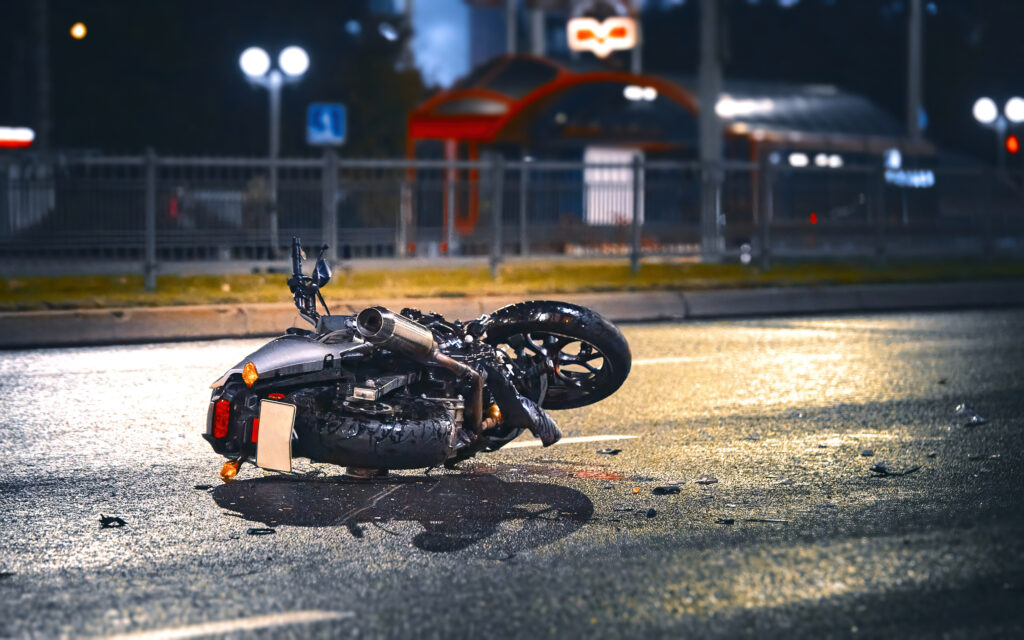 damaged motorcycle on asphalt after a car accident