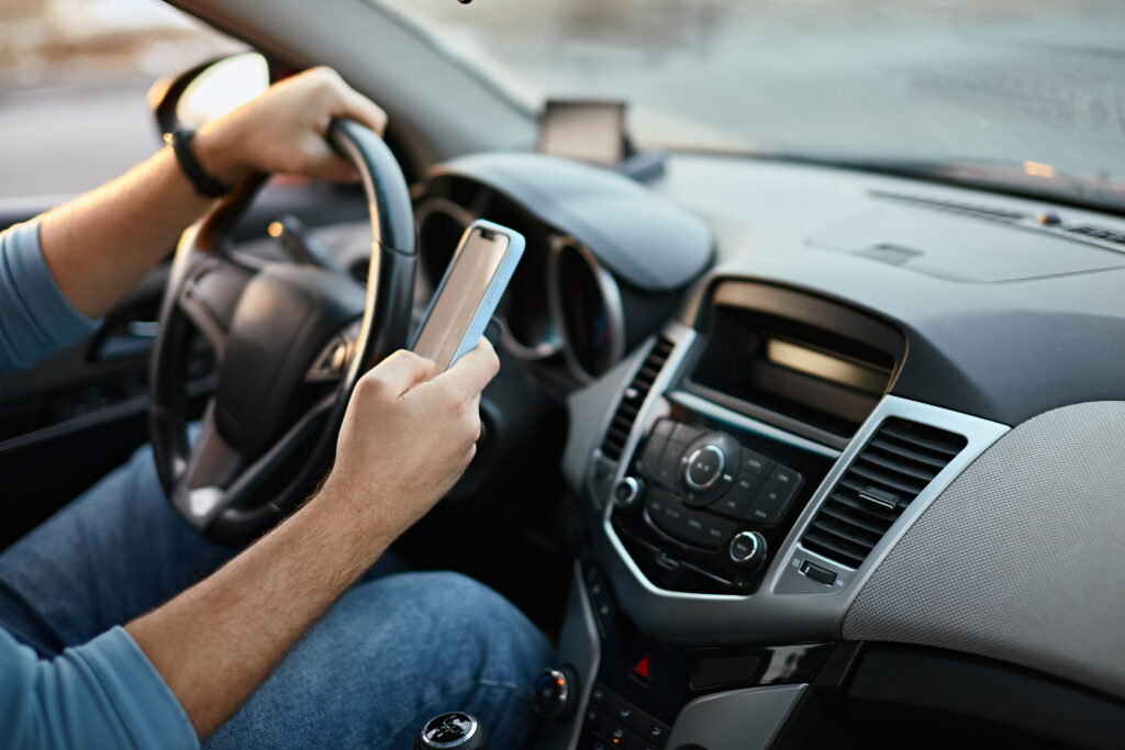 a man driving a car while using a cell phone