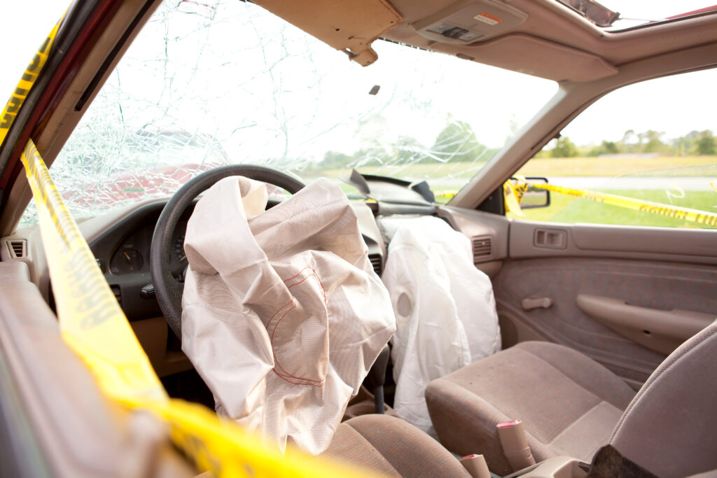 airbags deployed on both driver and passenger sides of a car in the aftermath of a car accident