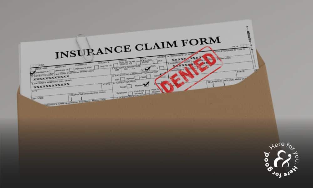 an insurance claim form filled out with a denial stamp on it after a car accident