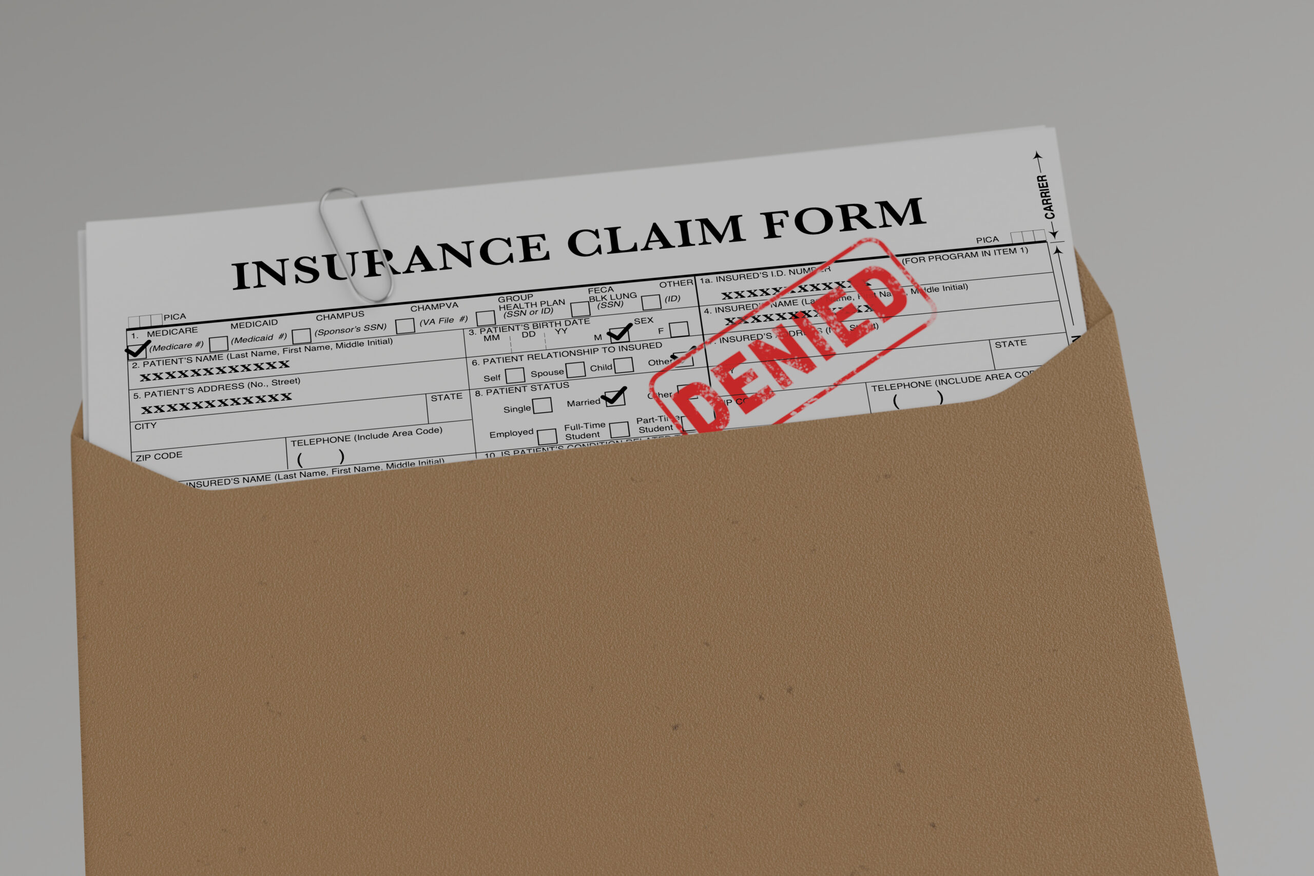 an insurance claim form filled out with a denial stamp on it after a car accident