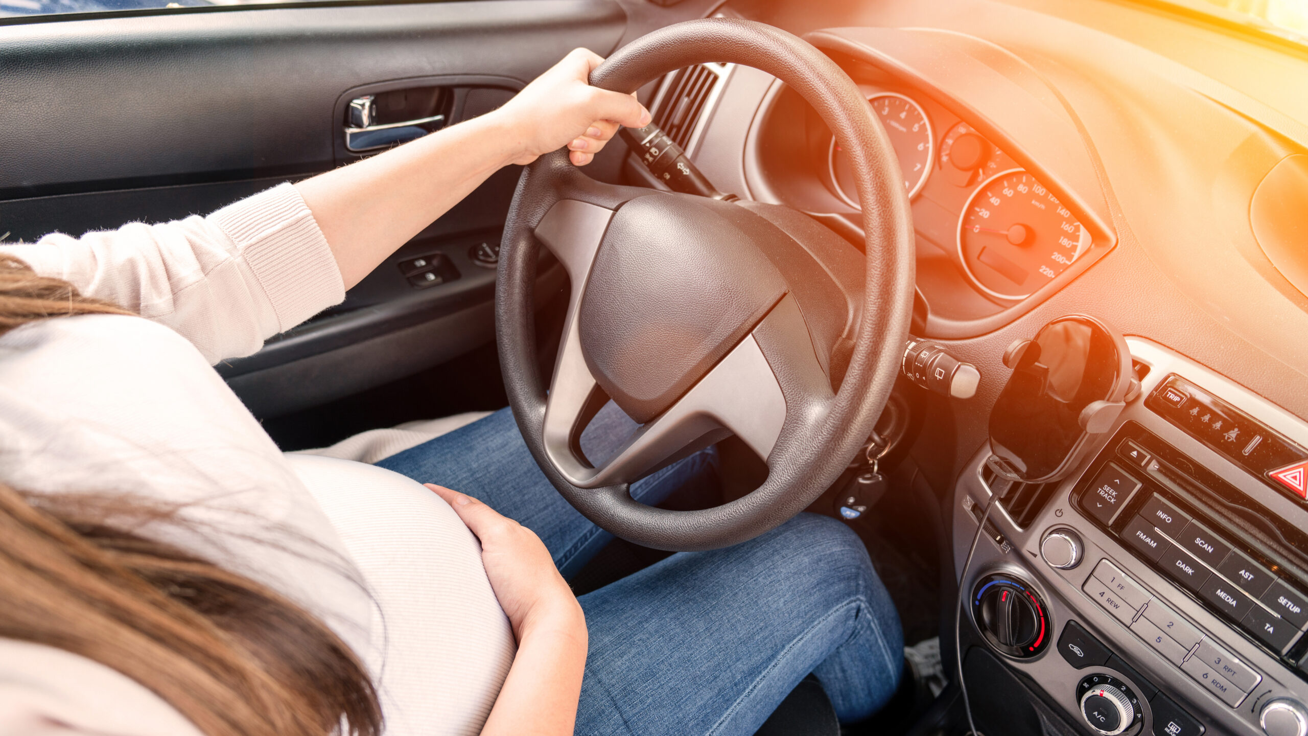 a pregnant woman driving a car