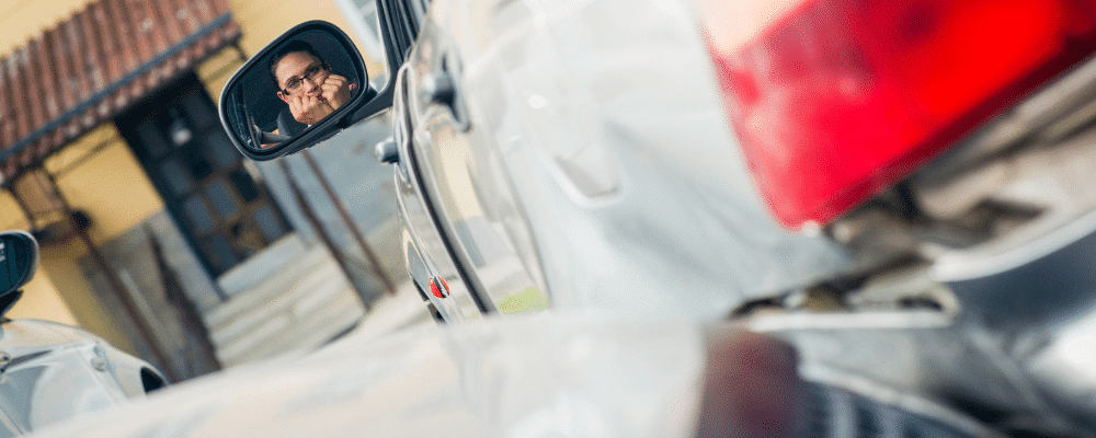 woman in accident looks scared in side mirror