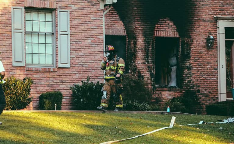 Firefighter coming out of a house