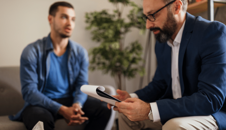 Young man in talk therapy with older male therapist