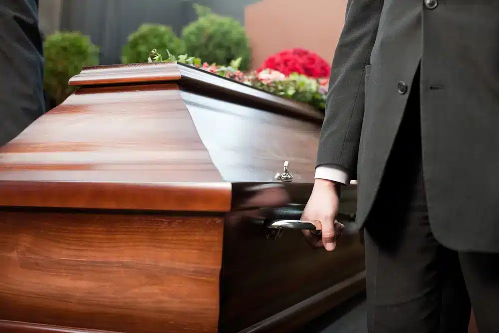 A pallbearer helping carry a casket