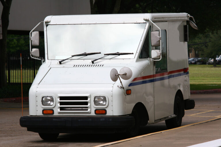 a white USPS mail truck delivering the mail