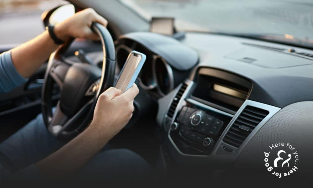 a man driving a car while using a cell phone