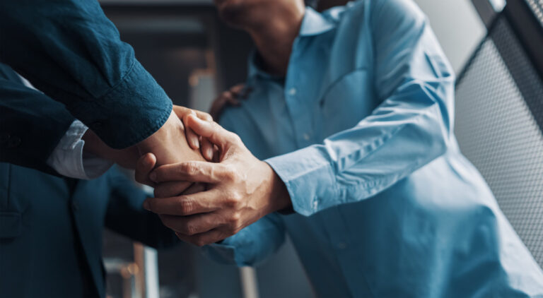 a client shaking hands with a car accident attorney wearing a business suit