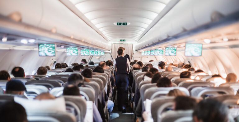 flight attendants serving passengers during flight in airplane cabin
