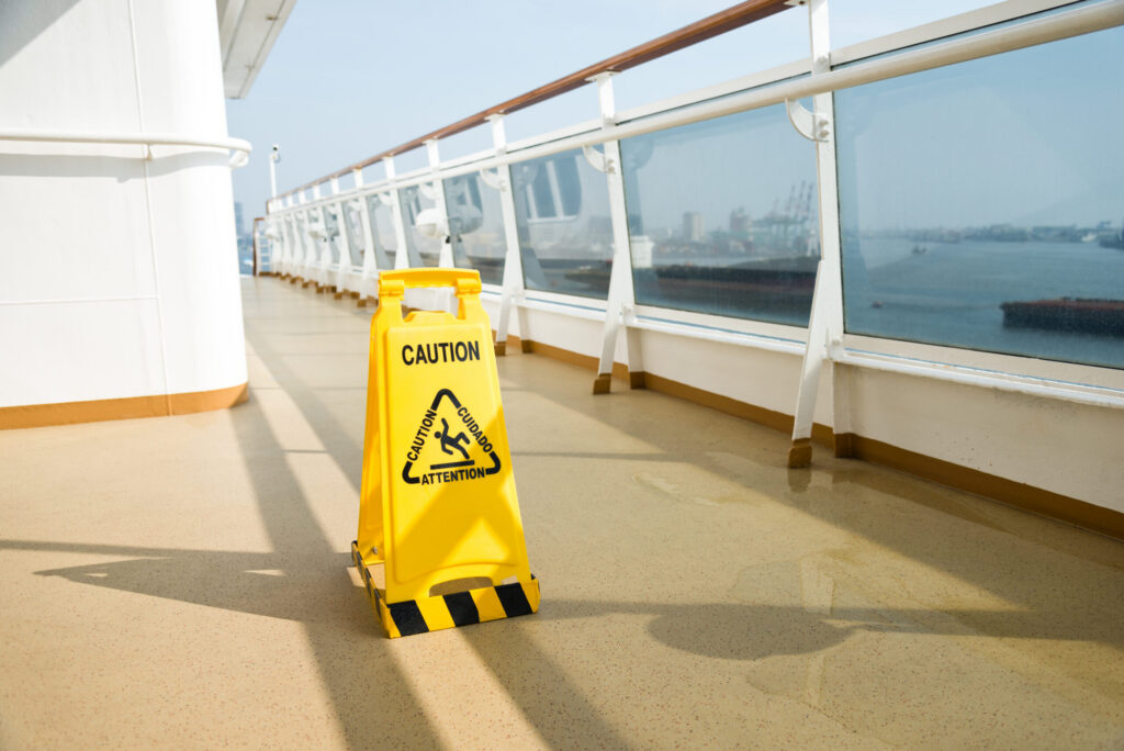 a wet floor sign on a slippery floor on a cruise ship deck out at sea