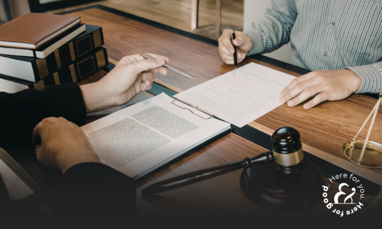 A person signing papers with their lawyer